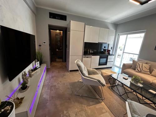 a living room with a tv and a couch and a table at George luxury living in Preveza