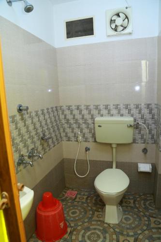 a bathroom with a toilet and a tub and a sink at Dean Dale Cottages in Thekkady