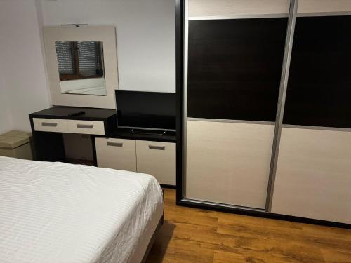 a bedroom with a white bed and a mirror at Bia's Apartament in Mamaia Nord