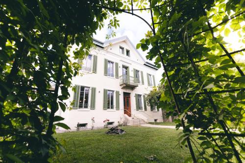 a white house seen through the trees at Villa Lorenzo Chambres & Restaurant Barcelonnette Hotel in Barcelonnette