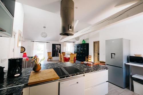 une cuisine avec des armoires blanches et un comptoir dans l'établissement Bergerie saint-claude, à Bessan