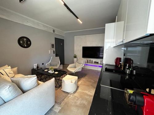a living room with a white couch and a kitchen at George luxury living in Preveza