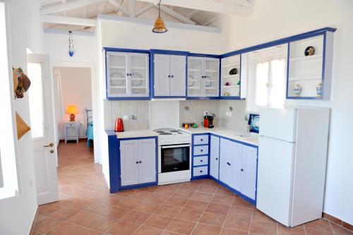 a kitchen with blue cabinets and white appliances at Hydra Erato in Hydra