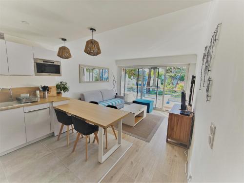 een keuken en woonkamer met een houten tafel en stoelen bij Le Capitole - Studio Plage Benoit - Escapade Hivernale in La Baule