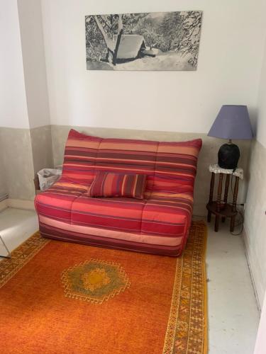 - un canapé rouge dans le salon avec une lampe dans l'établissement Duplex, à Saint-Maur-des-Fossés