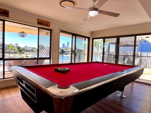 a red pool table in a room with windows at Waterfront Family House with Pool, BBQ in Gold Coast