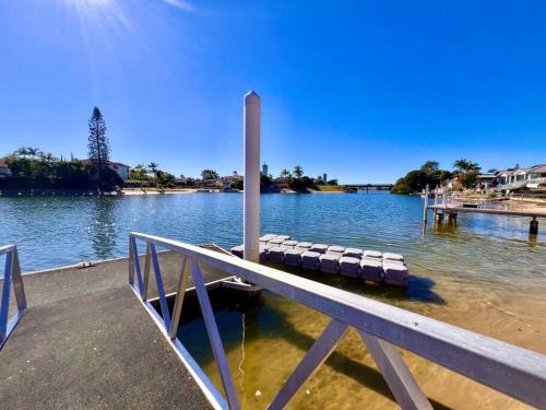 a dock with a row of benches on the water at Waterfront Family House with Pool, BBQ in Gold Coast