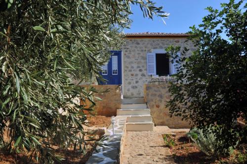 a house with a blue door and some trees at Hydra Erato in Hydra