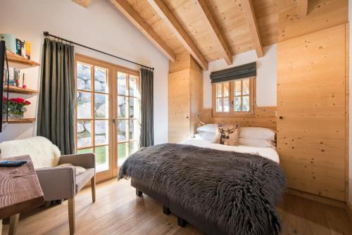 um quarto com uma cama grande e uma janela em Chalet Alexia em La Tzoumaz
