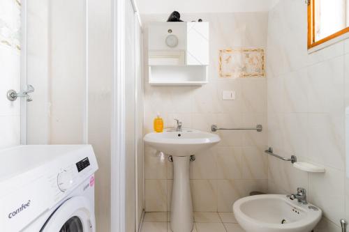 een witte badkamer met een wastafel en een wasmachine bij BluMarine by Vivimy in Gallipoli