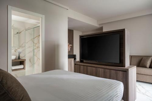 a bedroom with a flat screen tv and a bed at Bolina Suite & Spa in Milano Marittima