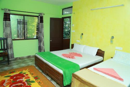 a bedroom with two beds and a window at Dean Dale Cottages in Thekkady