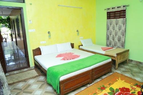 a bedroom with two beds and a chair in it at Dean Dale Cottages in Thekkady