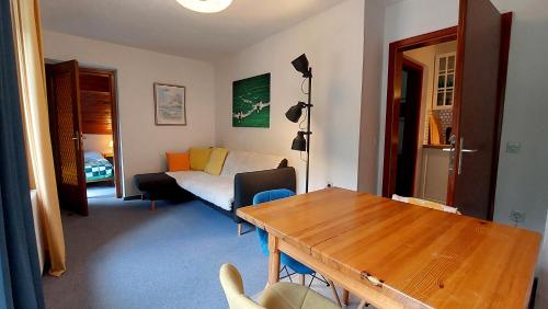 a living room with a table and a bed at Hiša ob jezeru - House by the Lake in Kranjska Gora