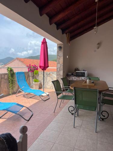 un patio con tavolo, sedie e ombrellone di Villa M a Bečići