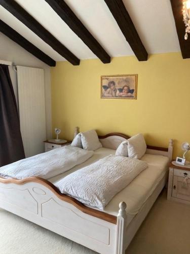 a bedroom with a white bed in a room at Duplex Ferienwohnung Edelweiss in Grächen