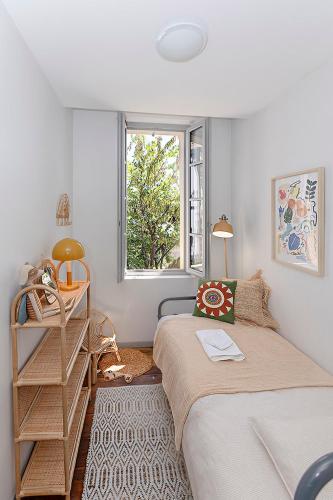 une petite chambre avec un lit et une fenêtre dans l'établissement La Terrasse Catalane, à Albi