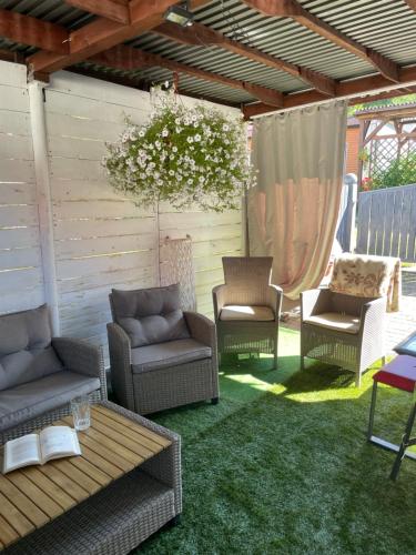 a patio with chairs and a table on the grass at Apartament u Danusi in Złoty Stok