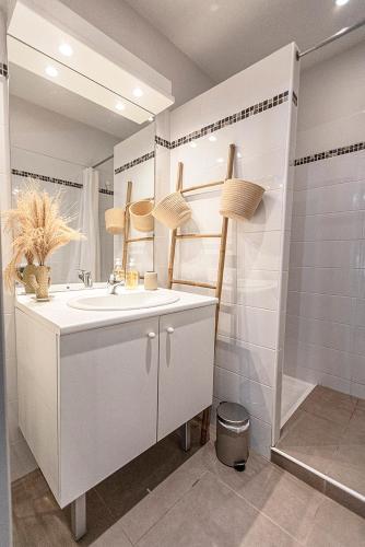 une salle de bain blanche avec un lavabo et une douche dans l'établissement La Terrasse Catalane, à Albi