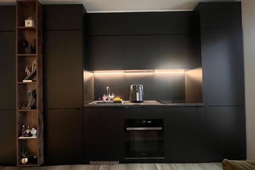 a kitchen with black walls and a stove top oven at Luxury Apartments in Creţuleasca