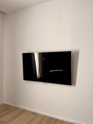 a television on a white wall in a room at Luxury Apartments in Creţuleasca