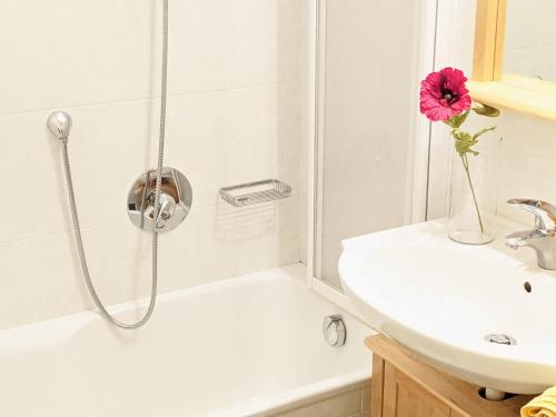 a bathroom with a shower with a vase with a pink flower at Vidora Apartments - Dolomites Escape in Alpe di Siusi (Seiser Alm) in Fiè