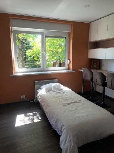 a bedroom with a large bed in front of a window at The Cottage in Murska Sobota