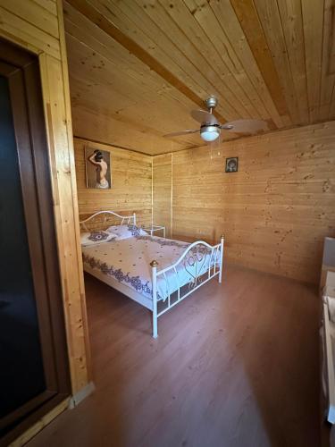 una camera da letto con un letto in una stanza di legno di Pensiunea Delia a Vadu