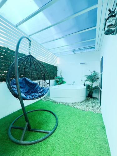 a hanging hammock in a room with green grass at Baan Sailboat Beach Kohlarn in Ko Larn