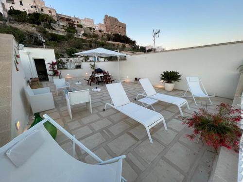 un gruppo di sedie e tavoli bianchi su un patio di Dimora di Mezzo a Castro di Lecce