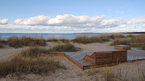 a wooden deck in the sand near the water at Lahepere Villa mini-villad in Kloogaranna