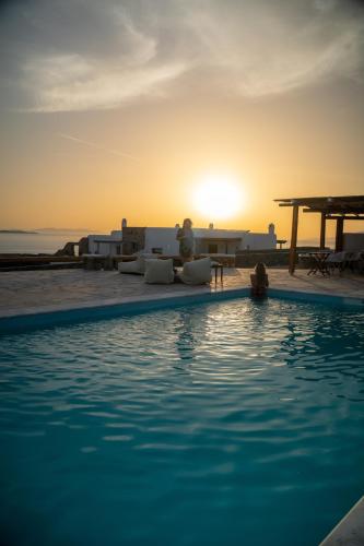 a swimming pool with a sunset in the background at Sofia's Bungalows Mykonos in Mýkonos City