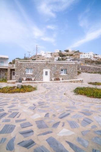 a stone courtyard with a building in the background at Sofia's Bungalows Mykonos in Mýkonos City