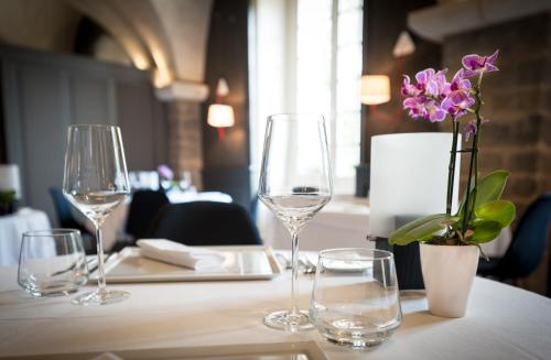 a table with wine glasses and a vase with flowers at Domaine de Saulon in Saulon-la-Rue