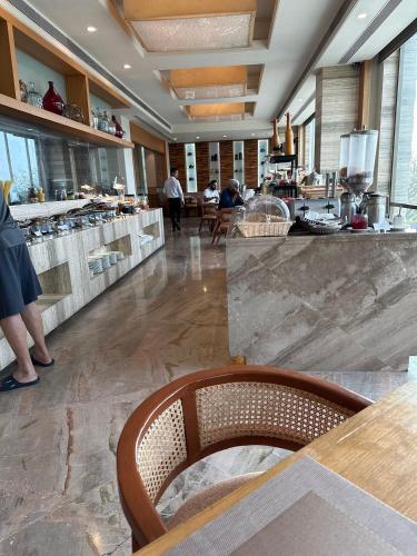 a restaurant with a counter with people in the kitchen at Efcee Sarovar Premiere Bhavnagar in Bhavnagar