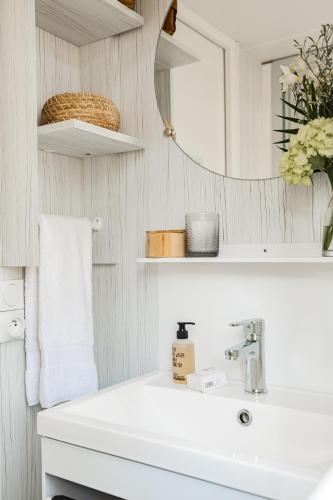a white bathroom with a sink and a mirror at Camping Arcobaleno in Marina di Bibbona