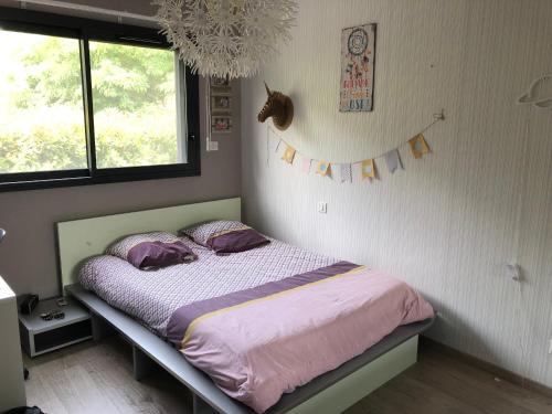 - une chambre avec un lit doté de draps violets et une fenêtre dans l'établissement Bella vita, à Arthès