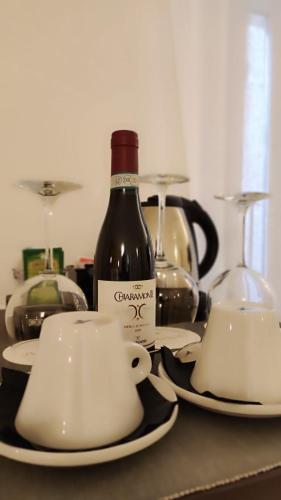 a bottle of wine and two cups on a table at Hotel Porta Reale in Noto