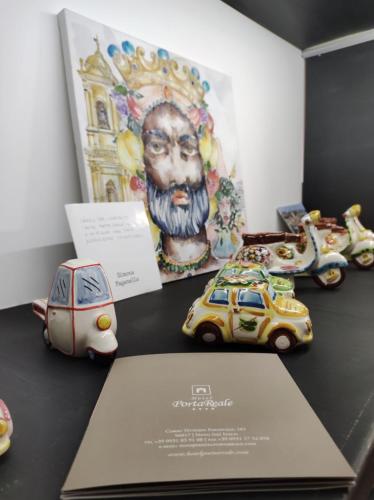 a group of toy cars on a table with a painting at Hotel Porta Reale in Noto