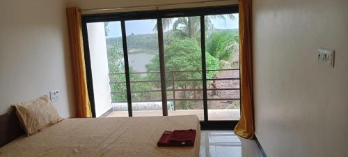 a bedroom with a bed and a large window at Hiran Holidays in Sasan Gir