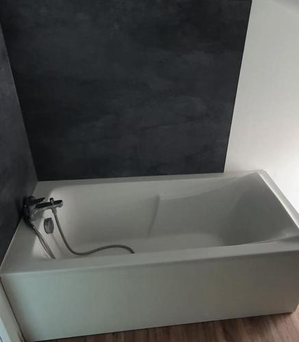 une baignoire blanche avec un robinet dans une pièce dans l'établissement Cosy #2 - Parking privé sur place, à Châlons-en-Champagne