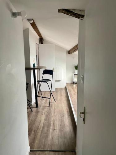 une porte ouverte menant à une chambre avec une table et des chaises dans l'établissement Cosy #2 - Parking privé sur place, à Châlons-en-Champagne