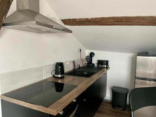 une petite cuisine avec un évier et une cuisinière dans l'établissement Cosy #2 - Parking privé sur place, à Châlons-en-Champagne
