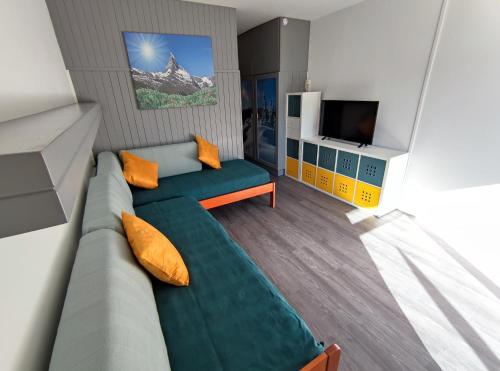 a living room with a couch and a television at Studio 4 personnes Sud rénové - pied des pistes in Superdevoluy