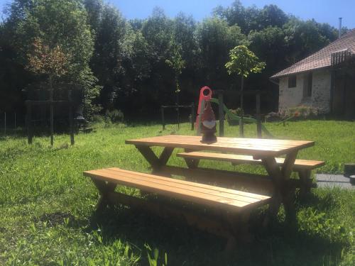a teddy bear sitting on top of a picnic table at Gîte des Buis de l'Ain in Groslée