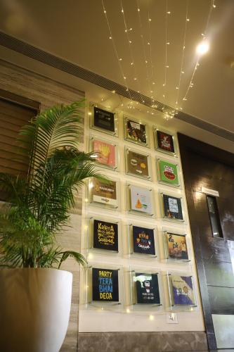 a wall filled with lots of books on a wall at Efcee Sarovar Premiere Bhavnagar in Bhavnagar