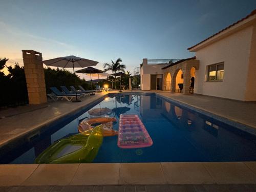 a swimming pool with two rafts in the water at Villa Imperial Sea-Caves Private Pool in Peyia
