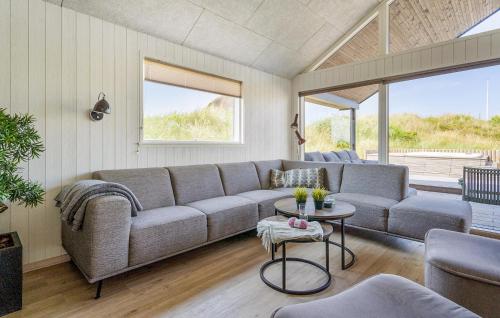 a living room with a couch and a table at 9 Bedroom Lovely Home In Ringkøbing in Søndervig