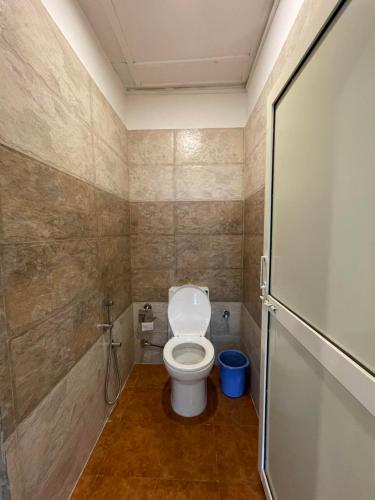 a small bathroom with a toilet in a room at Eevolve Dharamkot - An Eco Hostel in McLeod Ganj