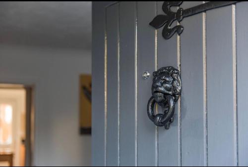 a locked door with a snake on it at Brook Cottage in Temple Ewell